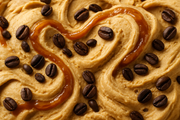 close-up image of swirl of caramel ice cream with coffee beans mixed into it