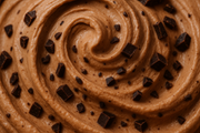 close-up image of swirl of light chocolate ice cream with chocolate chunks