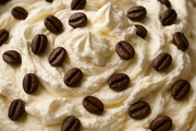 close-up image of vanilla ice cream with whipped cream and coffee beans mixed in