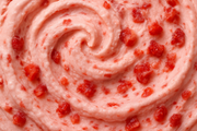 closeup image of swirl of strawberry ice cream with bits